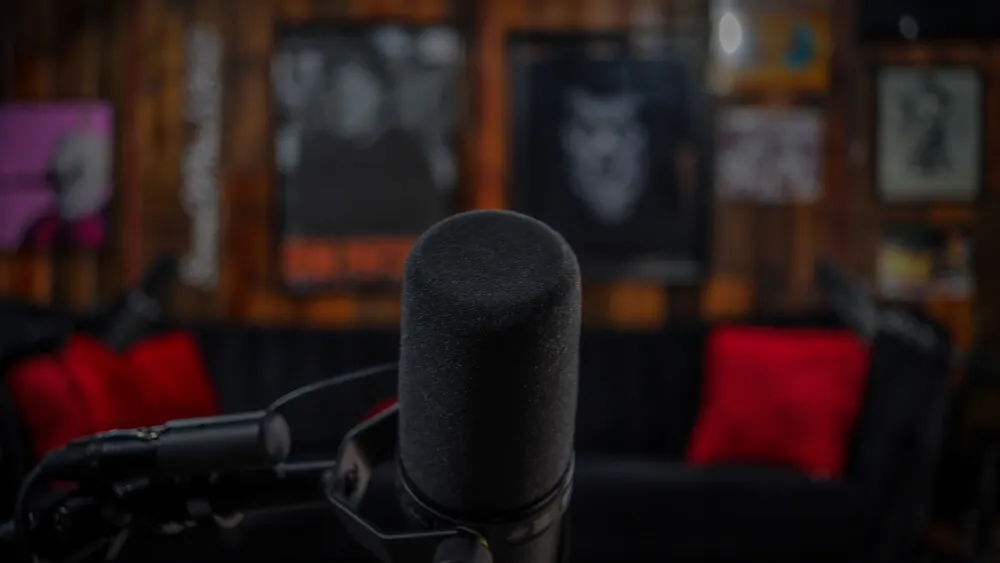 Podcast studio with comedy poster backdrop